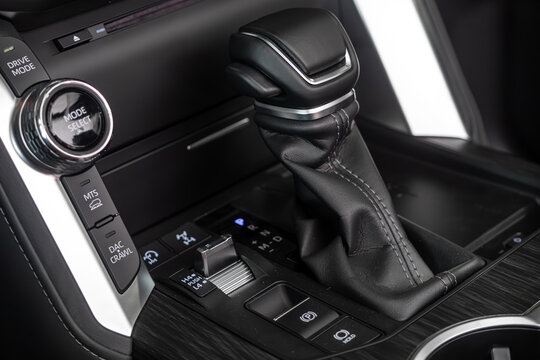 Novosibirsk, Russia - February  21 , 2024:    white Toyota Land Cruiser 300  , Close up of the manual gearbox transmission handle. Accelerator handle and buttons in a new car.