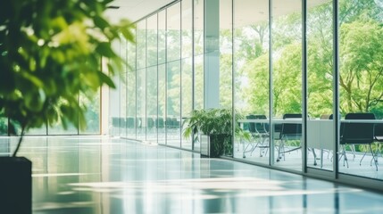 Blurred empty modern open space office with large windows and green trees