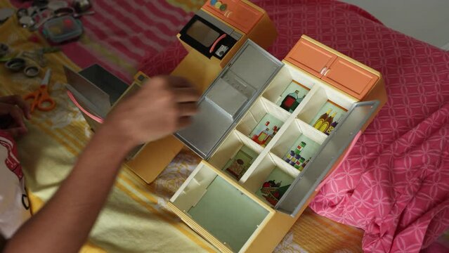 Kid child playing with cupboard box in kid room arranging things