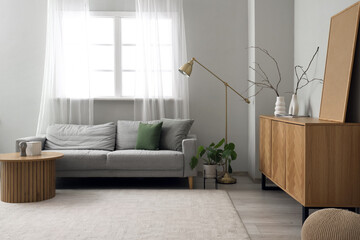Interior of modern living room with wooden sideboard and grey sofa