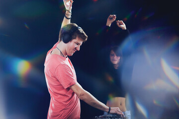 DJ elated, dancer enjoys, amidst vibrant lights