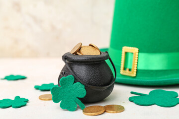 Pot with golden coins, leprechaun hat and clovers on light grunge background. St. Patrick's Day...