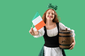 Young waitress with barrel and flag of Ireland on green background. St. Patrick's Day celebration