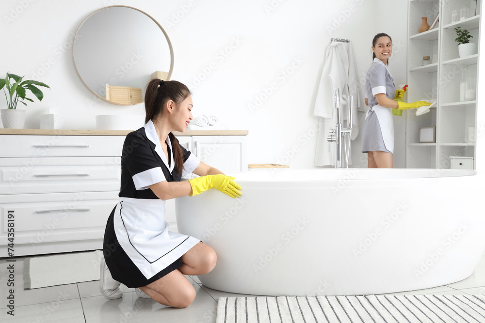 Canvas Prints Young chambermaids cleaning in bathroom