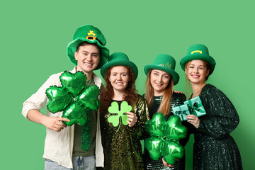 Group of people with clovers and gifts on green background. St. Patrick's Day celebration
