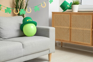 Interior of festive living room with grey sofa and decorations for St. Patrick's Day celebration