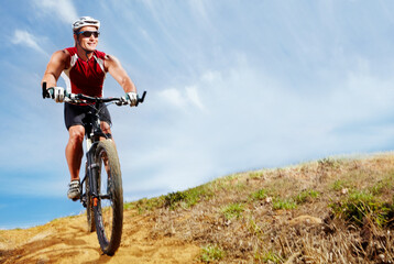 Nature, cyclist and man athlete with bicycle in park for marathon, race or competition training. Fitness, sports and male person cycling on bike for cardio workout or exercise in outdoor forest.