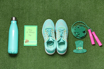 Sneakers, skipping rope, water bottle and decorations for St. Patrick's Day celebration on green grass background