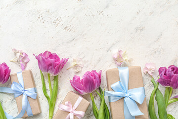 Beauty wrapped gift boxes and floral decor on light background