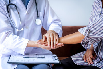 The doctor hands holding patient hand to encouragement and explained the health examination...
