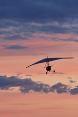 Hang glider on a motor on a summer evening against the backdrop of a sunset sky. Extreme sport....