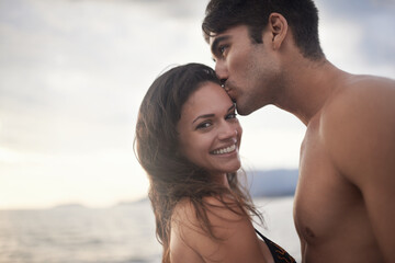 Portrait, smile and couple kiss at ocean on vacation, holiday or travel together at sunset. Face, man and happy woman at sea for adventure, romance or connection in summer by water for love on mockup