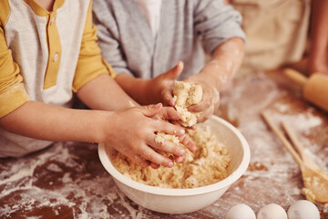 Kids, baking and hands in kitchen with dough, home and learning with ingredients for dessert cake. Children, kneading and playing with flour on table, love and pastry recipe for biscuits on holiday