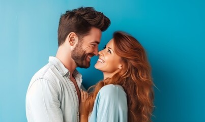  Portrait of smiling romantic couple looking each other,  insulated on blue background. A handsome bearded man and a beautiful woman standing together outdoors. Love, relationship conception 