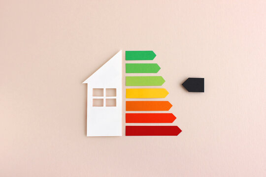 House with energy efficiency scale made with hand cut paper - color image for ecological housing, bio energetic house, energy class