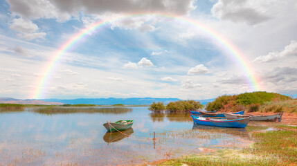 Marmara lake with lot of sandal (Boat) amazing rainbow in the background - Manisa, Izmir