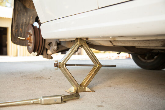 Car resting on jack while changing to spare tyre