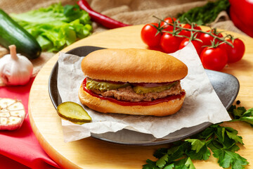 Sandwich with meat cutlet, cucumber and ketchup. Fast food.