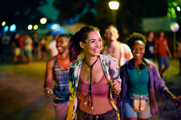 Happy woman and her friends on summer music festival at night.