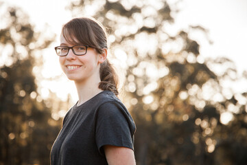 Portrait of a happy teenage girl with glasses smiling at the camera