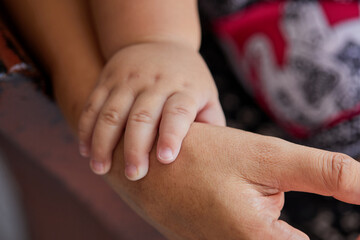 Midsection of baby hand holding mother hand