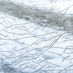 Cracks on glass as an abstract background. Texture