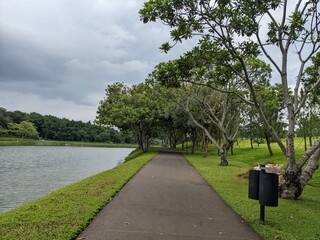 Fototapeta premium Mini jogging park on the Semarang Central Java with lake, cloudy vibes and blue sky. The photo is suitable for park background, relax and enjoy place content media.