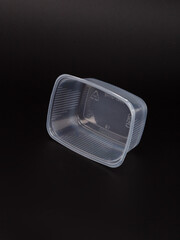 Empty plastic disposable food container, transparent lid isolated on black background.