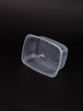 Empty plastic disposable food container, transparent lid isolated on black background.