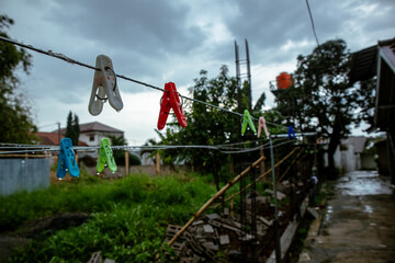 the blue sky behind the clothesline and clothespins wet from the rain