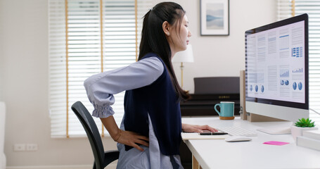 Asia young people cramp low body muscle worry in chronic tough issue, arthritis sciatica spine hip risk. Staff tired weak stress workforce job effect from bad posture sit on chair office syndrome.