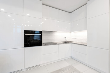 Fototapeta na wymiar Modern Home Interior. Kitchen with Sink and Black Oven. White Furniture. LED Light. Luxury Home