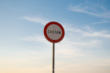 Passing without stopping prohibited customs traffic sign writing English, isolated sunset sky.