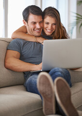 Laptop, smile and woman embracing man on sofa networking on social media, website or internet. Happy, love and female person hugging husband reading online blog with computer in living room at home.