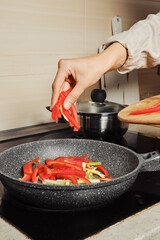 Dropping sliced bell pepper into skillet