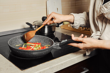 Unrecognizable woman stirring vegetable dressing with wooden spatula