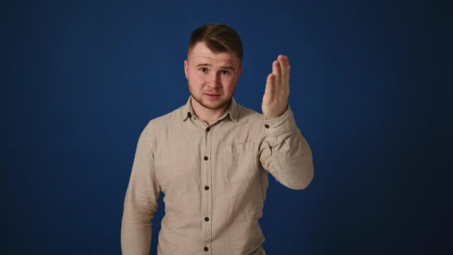 Regretful man gesturing disappointment over wrong decision on blue background
