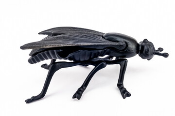 A purchased (consumer) figurine of a fly made of cast iron in close-up on a white background