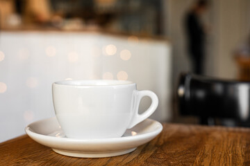 A white cup of black coffee on a saucer on the wooden table in a cafe - 744462949