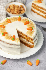 Homemade carrot cake made with walnuts, iced with cream cheese. Sweet dessert.