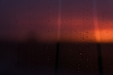 windows covered with raindrops with sunset back light