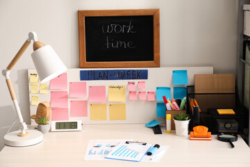 Business process planning and optimization. Workplace with lamp, colorful paper notes and other...