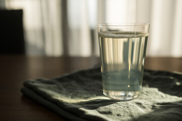 Glass of tonic water on linen napkin indoor