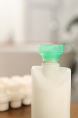 Mini bottle of cosmetic product on blurred background, closeup