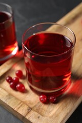 Tasty refreshing cranberry juice and fresh berries on grey table