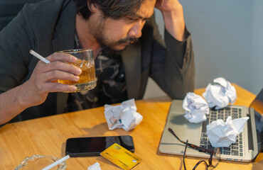 Bearded male hold head with hands look down sitting at office feels depressed desperate, drinking strong alcoholic