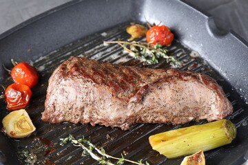 Delicious grilled beef meat and vegetables in pan on table, closeup