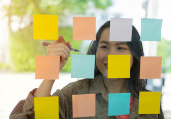 Selective focus of businesswomen at office and use post it notes to share idea.