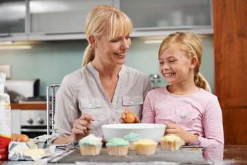 Baking, mom and child with cupcake in kitchen and teaching skill in home together to relax. Family,...