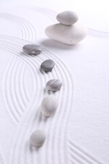 Fototapeta na wymiar Zen garden stones on white sand with pattern